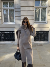a lady wears a light brown overcoat with a matching scarf
